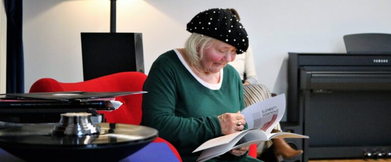 Starsza kobieta czytająca magazyn w bibliotece